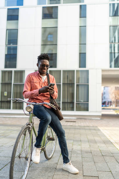 istock Young man with bike using cell phone 2192639351