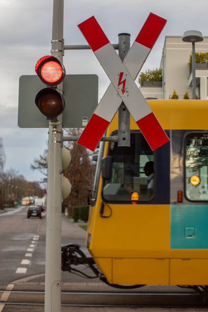 istock German Light Rail Train Crossing a Road with Red Light and Crossing Sign 2192640259