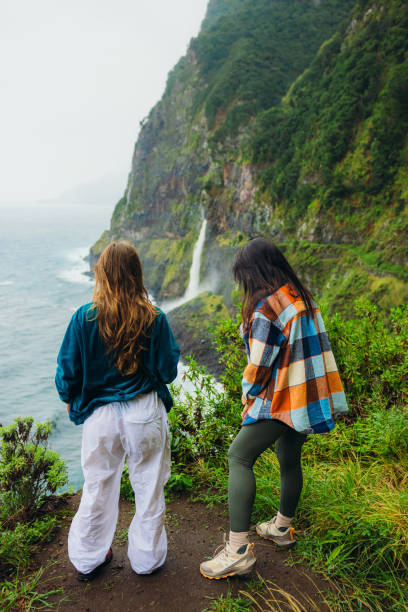 istock Two Travellers Admiring Scenic Waterfall by the Ocean 2192644797