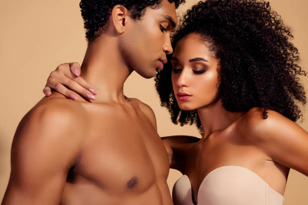 istock Sensual bonding between attractive afro couple celebrating valentine's day with passion on beige background 2192647675