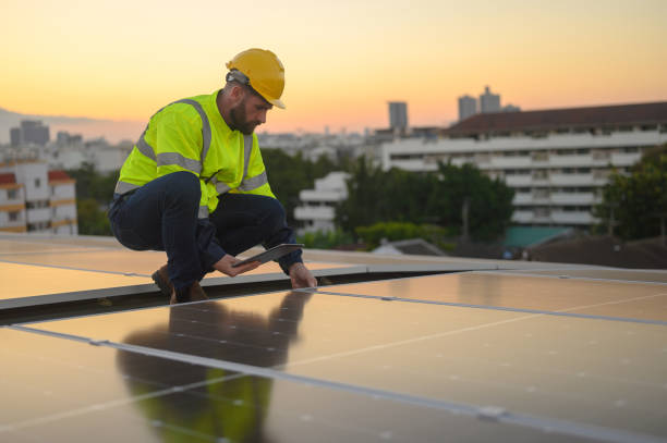 istock Male engineer works installing solar panels on the roof. Engineer or worker working on solar panels or photovoltaic cells on the roof of a business building. 2192652075