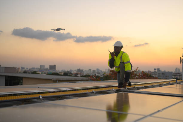 istock Male engineer works installing solar panels on the roof. Engineer or worker working on solar panels or photovoltaic cells on the roof of a business building. 2192652240