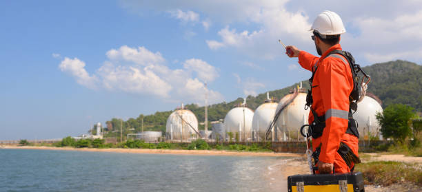 istock Front view of engineer standing holding tool back and communicating with the team via walkie-talkie 2192652251