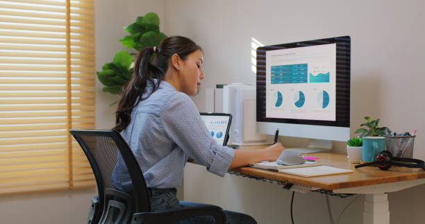 istock Smart Gen Z tech talent workforce typing SEO sale report on desktop PC happy work easy relax at home office. Remote WFH reskill upskill job MBA study of young people asia woman examine big data graph. 2192656456