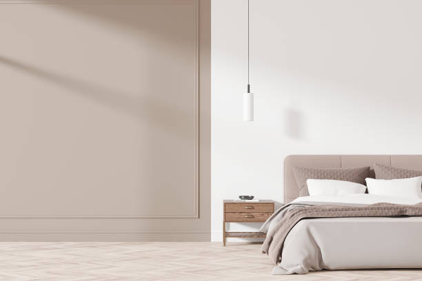 istock Modern bedroom interior with neutral tones featuring bed, side table, and minimalist lighting. Blank wall for mockup or design layout. 3D Rendering 2192656736