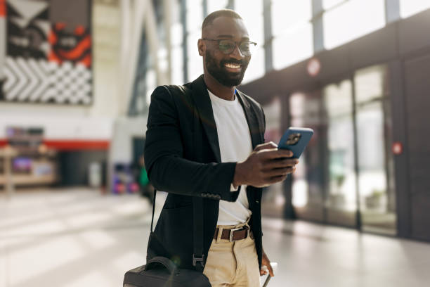 istock Businessman using smartphone while walking in airport terminal 2192657459