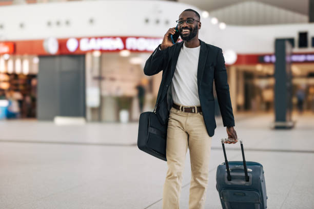 istock Businessman walking in airport terminal while talking on phone 2192658098
