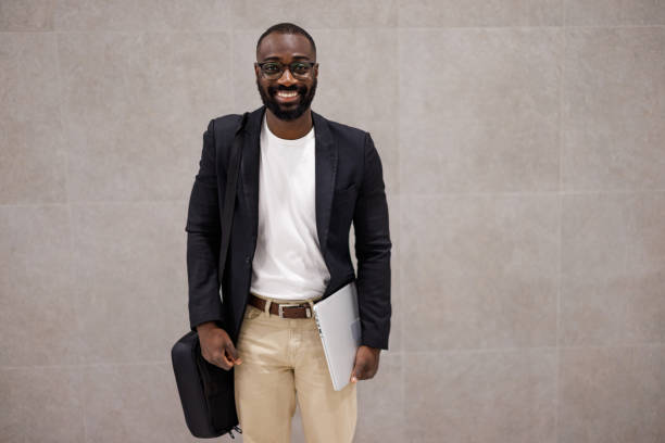istock Young businessman smiling and holding a laptop 2192658119