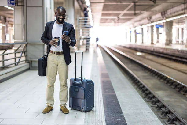 istock Businessman waiting for train using smartphone and drinking coffee 2192658177