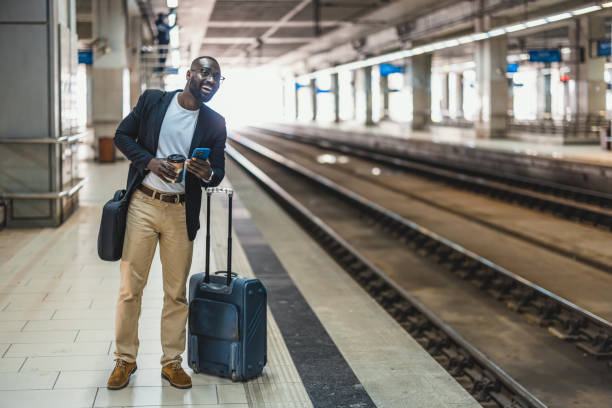 istock Businessman waiting for the train while using his smartphone and drinking coffee 2192658196