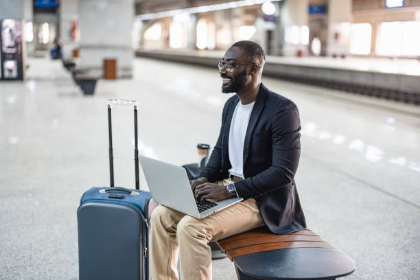 istock Businessman working on laptop while waiting for train at station 2192658208