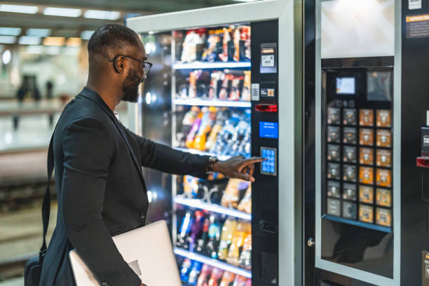 Businessman buying snack at vending machine in train station