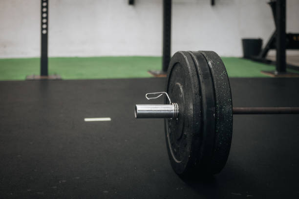 istock Barbell with weight plates in gym setup 2192661690