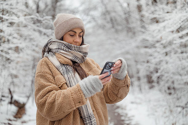 istock Young woman using phone in the winter mountain 2192661749