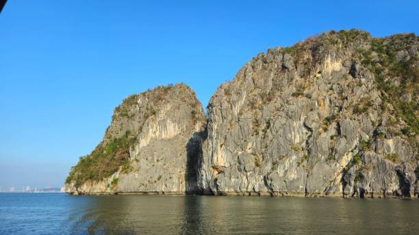 istock Limestone rock islands at Ha Long Bay, Vietnam, feature steep, rugged limestone formations characterized by vertical striations and small caves. 2192665122