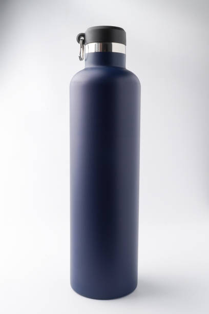 istock Someone hand is holding matte dark blue colored drinking bottle. Reusable water bottle container. Thermos travel tumbler. Insulated drink container. Isolated on white background. 2192670159