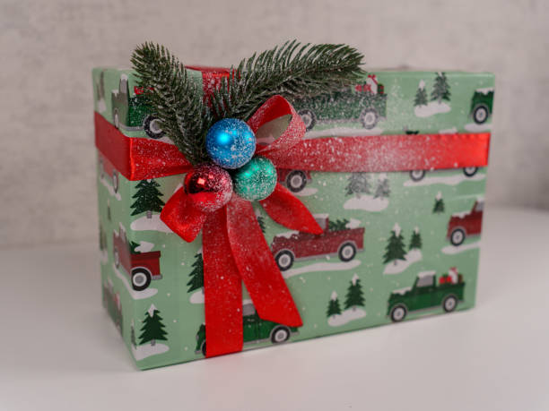 istock Festive gift box with holiday decorations featuring vintage trucks and pine 2192671200