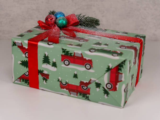 istock Festive wrapped gift with red trucks and holiday decorations on display 2192671213