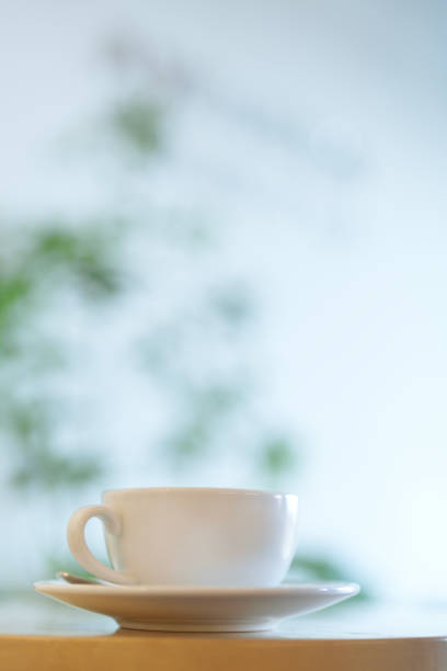 istock White ceramic coffee cup and saucer on a wooden table with a soft blurred background 2192671517