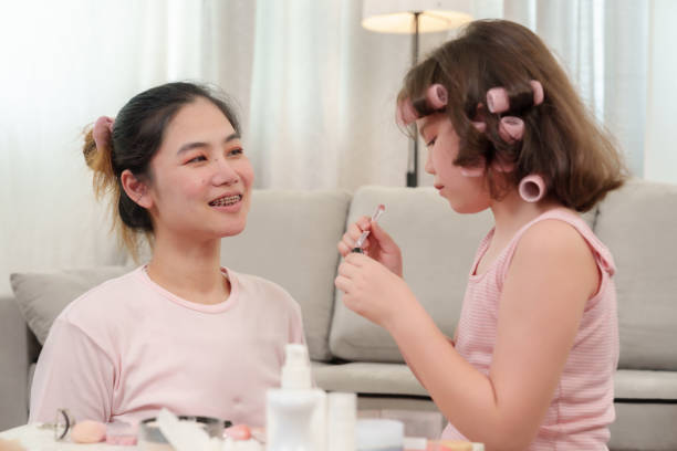 istock Young child practicing makeup techniques with mother at home, showing creativity and family bond. Intimate and playful moment reflecting love, learning, and happiness in a cozy environment. 2192676832
