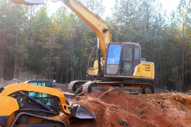 istock Excavators and machinery working on a construction site in a forested area during daylight hours 2192678409