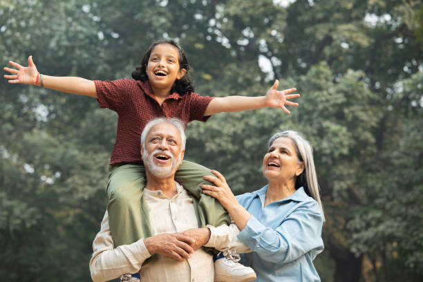istock Old woman standing with senior man carrying girl on shoulders 2192680607
