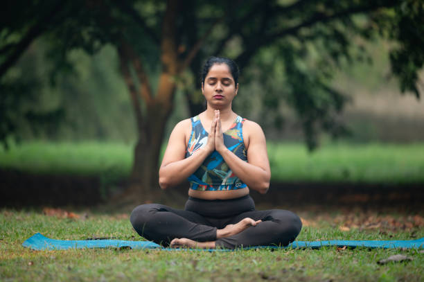 istock Woman in sportswear practicing yoga tree pose at park 2192683183