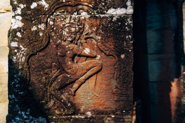 Intricately carved ancient stone Apsara figure on temple walls in Angkor Wat, Cambodia, showcasing cultural artistry. Captures historical heritage within the vibrant textures and sunlight of the temple surroundings.