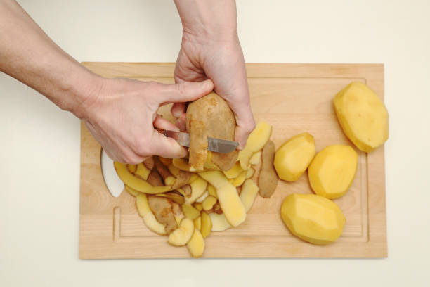 istock woman peeling raw potatoes 2192687930