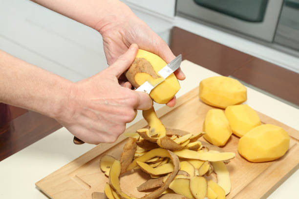 istock woman peeling raw potatoes 2192687941