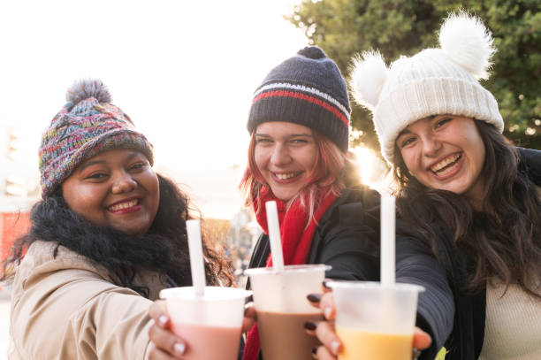 istock Three smiling young women toasting with bubble tea outdoors in winter clothes 2192688174