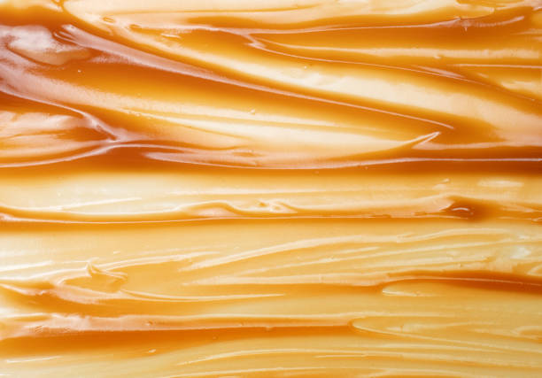 Caramel smeared background. Texture of a viscous golden substance