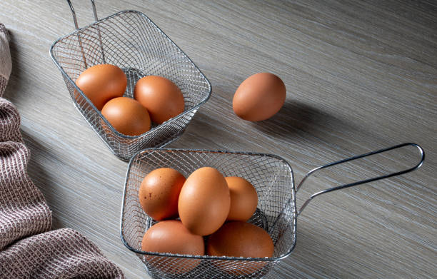 istock Chicken eggs in metal basket and linen napkin on kitchen table 2192689488