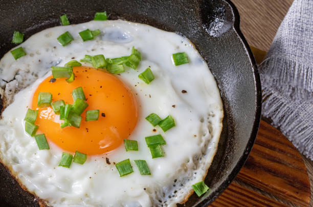 istock Fried egg with green onions in a cast iron skillet, top view,close up 2192689506