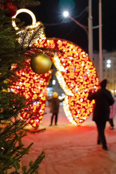 istock Glowing Christmas installations on the sidewalk. Shining decorations and a New Year tree on the street 2192689931