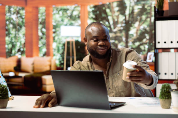 istock Business owner working remotely on a laptop and drinking coffee 2192692152