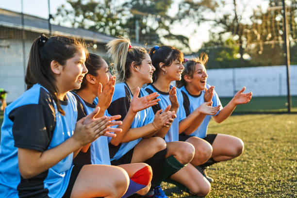 istock Happy soccer girls cheering from sideline during match 2192695968