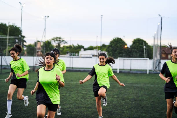 Girls soccer team exercising during outdoor training Girls soccer team running and exercising during training on an outdoor field. drill team stock pictures, royalty-free photos & images