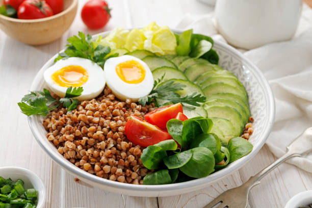 istock Buckwheat groats with avocado, various vegetables and soft-boiled egg, focus on groats, close up view. 2192697500