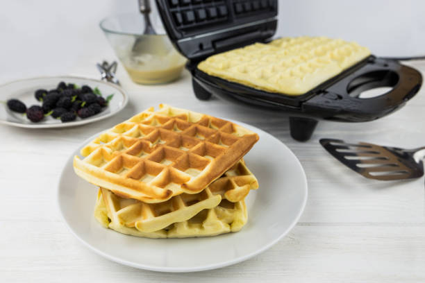 istock Belgian waffles on white.Sweet waffles in a white plate. Cooking Belgian waffles. 2192698512