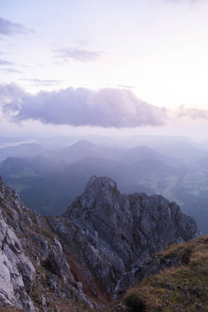 Sunrise over forest and mountains in mist