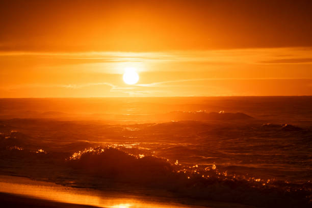 Golden hour on the sea, waves crash to shore