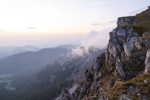 Sunrise over forest and mountains in mist