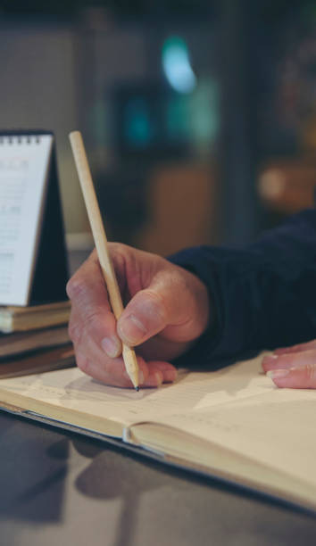 istock Planner or organizer writing daily appointment On Calendar book and using smartphone. Asian man hand plan timetable meeting agenda and note schedule business in diary. Planner concept-vertical image. 2192700137
