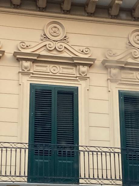 istock Windows with shutters and wrought iron balcony decorated scrolled pediment with rosette relief. 2192700821