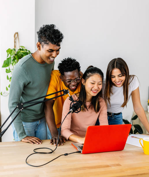 istock Young group of student friends having fun doing podcast using laptop at home 2192706625