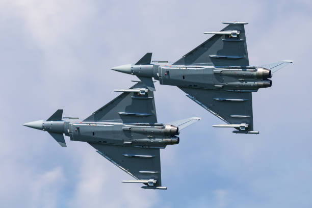 Modern fighters jet flying over sea.  F-22 Raptor flying over clouds.