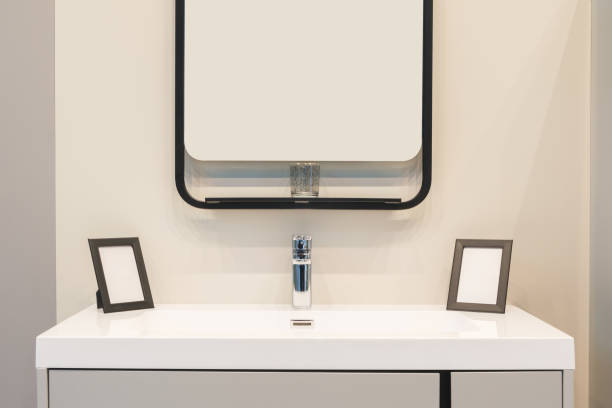 istock A bathroom sink with a mirror above it and two small black frames on the counter 2192708922