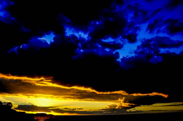 A beautiful blue sky with a sunset in the background. The sky is filled with clouds and the sun is setting