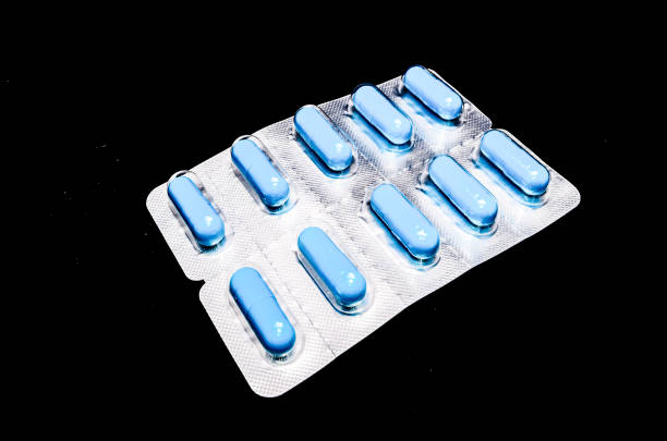 A pack of blue pills with a white label. The pills are in a plastic wrapper